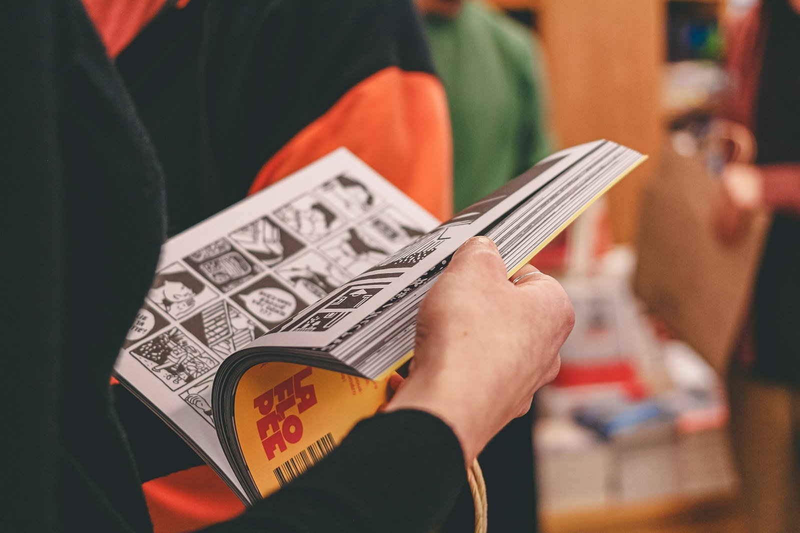 Person flipping through a printed comic volume
