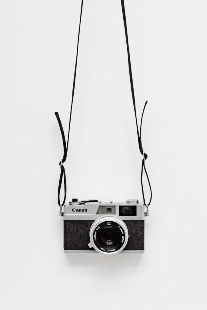 Black and gray Canon camera on white surface